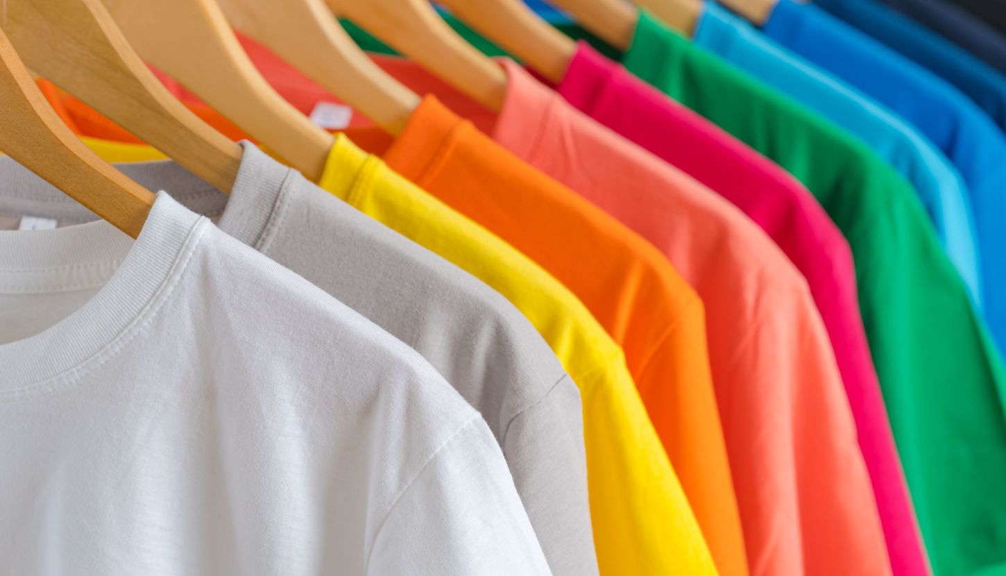 Close up of Colorful t-shirts on hangers, apparel background